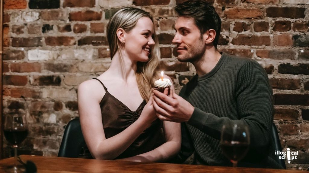 couple holding a cupcake with a candle on top. / why you should date a reader?
