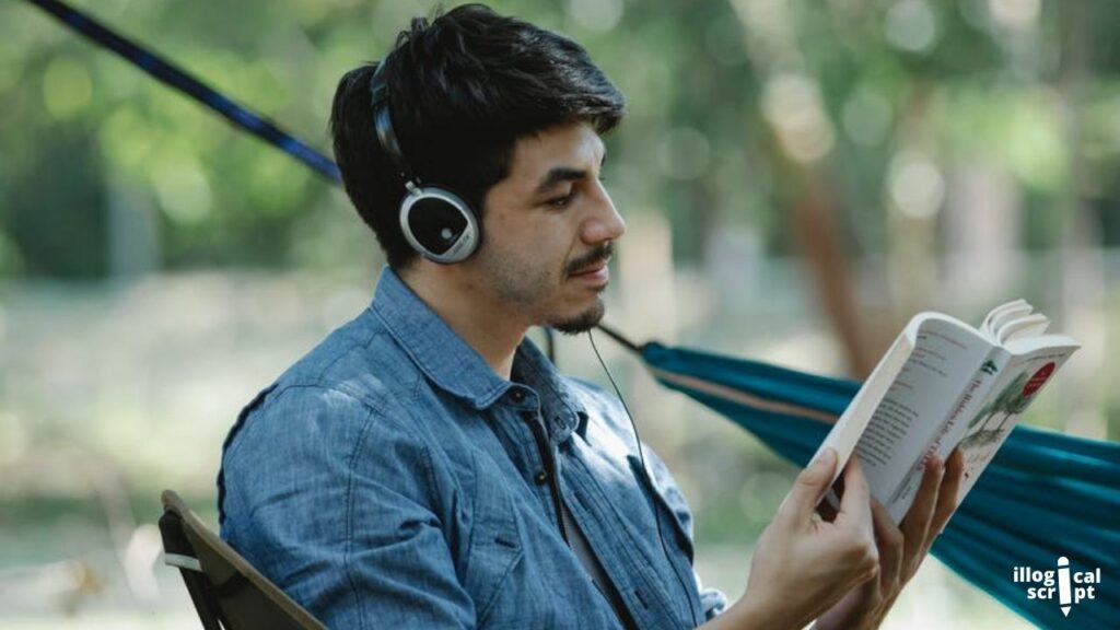 a man reading a book with headphones on