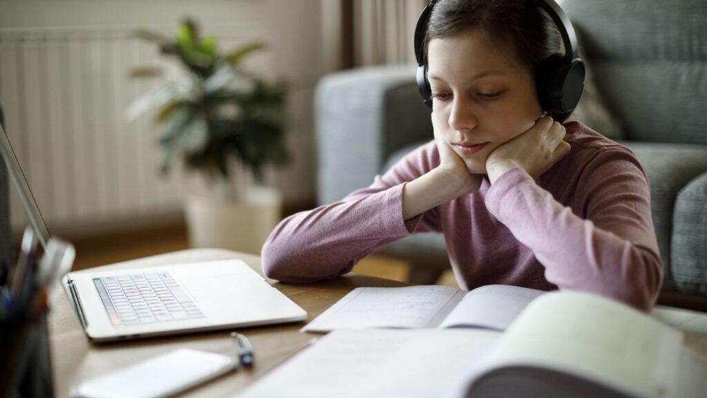 a girl reading with headphones on