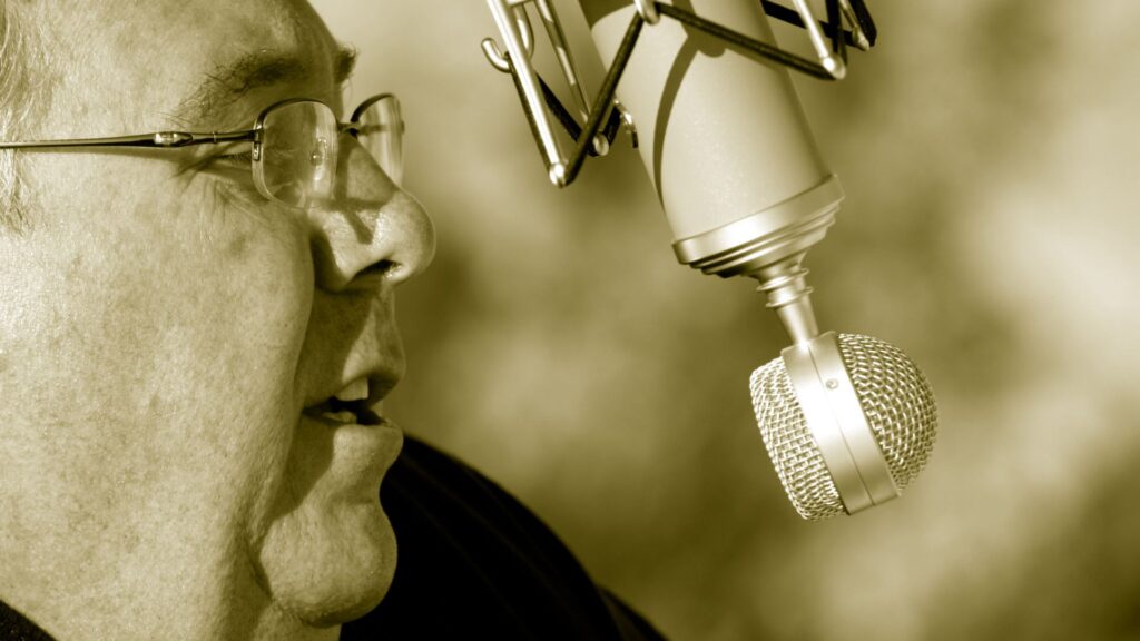 old man with spects narrating on the mic.
