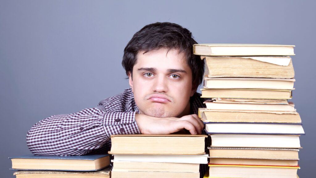person with a check-shirt is sad with books.