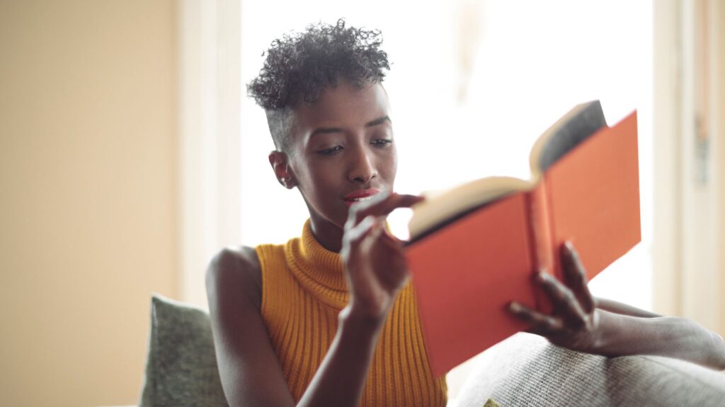 black women in orange dress is reading book.  | How to Stop Subvocalizing
