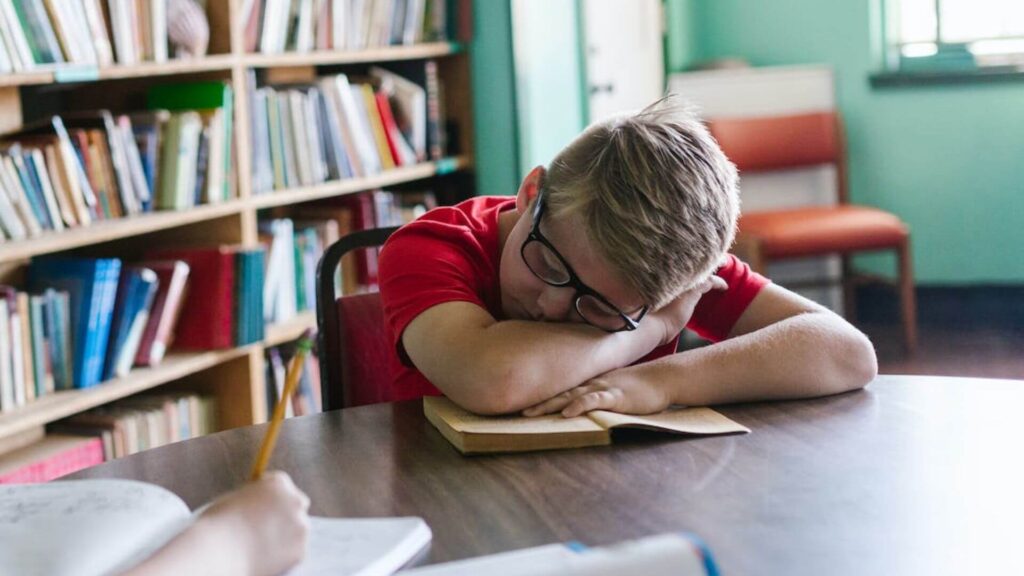 Boy sleeping while reading. | Ways to Stay Awake while Reading
