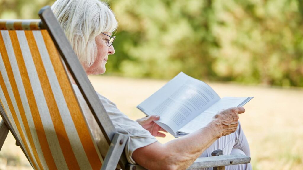 Old white women reading a book. | Can Reading Prevent Dementia?