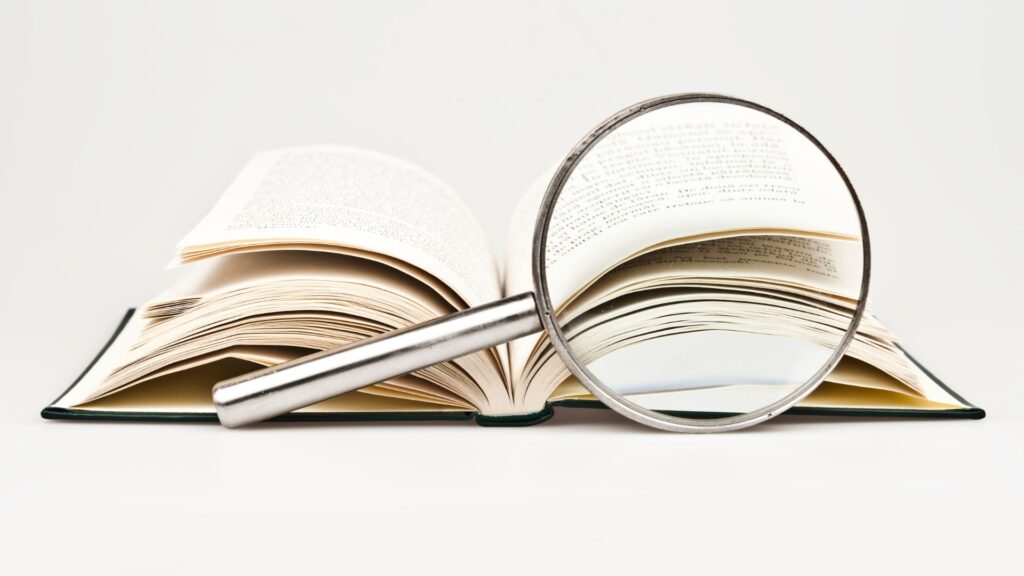 book with magnifying glass, | How to retain what you read
