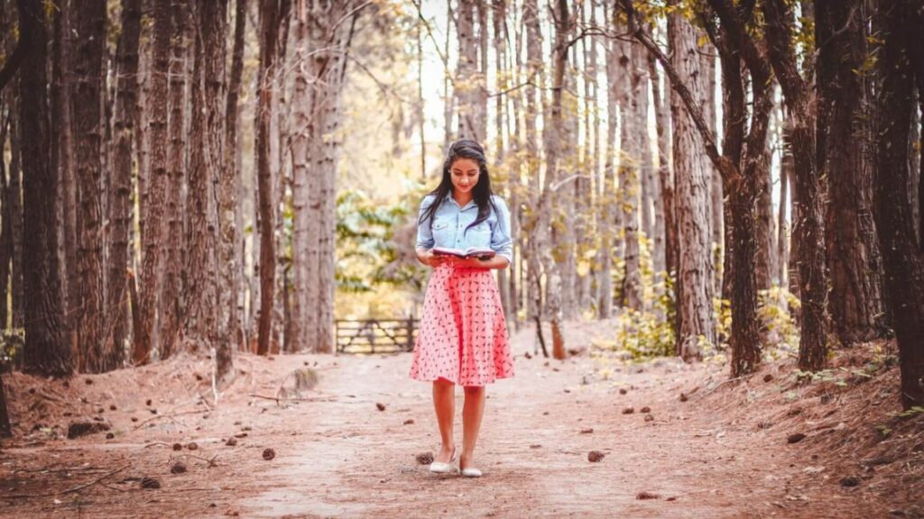 Women in a skirt reading while walking. | Ways to Stay Awake while Reading