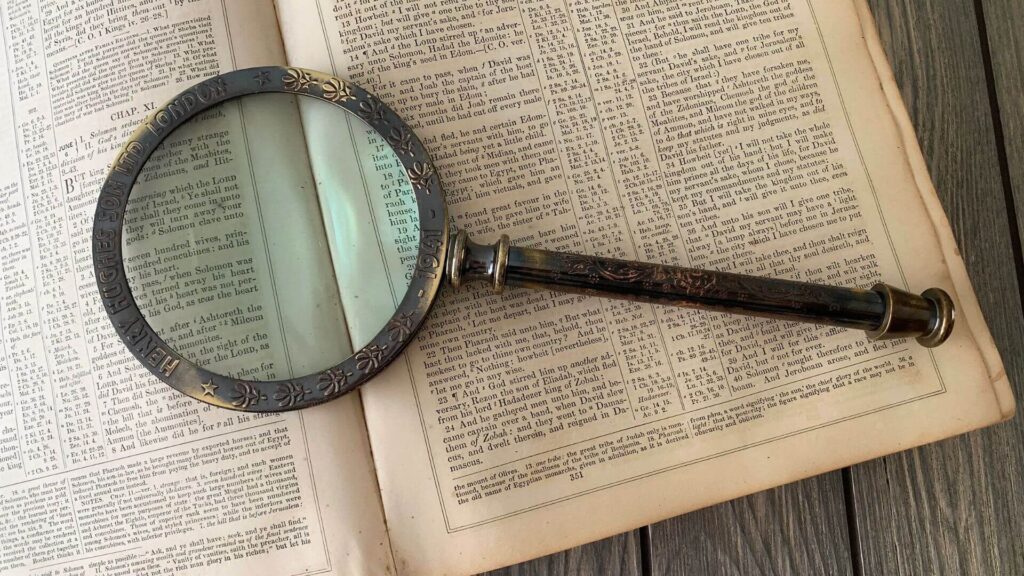 A picture of magnifying glass over a book  | Skimming and Scanning Techniques