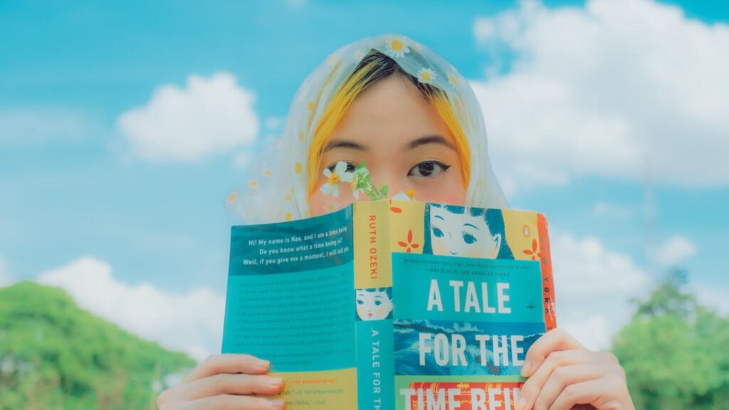 a girl with a book in front of her face